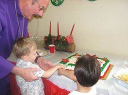 Helping Fr Tim cut Baby Jesus' cake